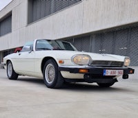 a white sports car parked in front of a building